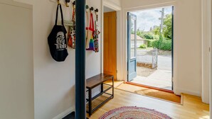 A modern interior with a bench, a wall-mounted bag rack, and a door leading to an outdoor area. - 4 bedroom accommodation in Hindolveston, near Holt (Hindolveston, near Holt)