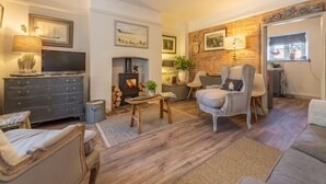Una sala de estar acogedora con chimenea, asientos cómodos y televisor.