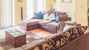 A living room with a sectional sofa, a small side table, and a patterned rug. - 1 bedroom accommodation in Malvern (Malvern)