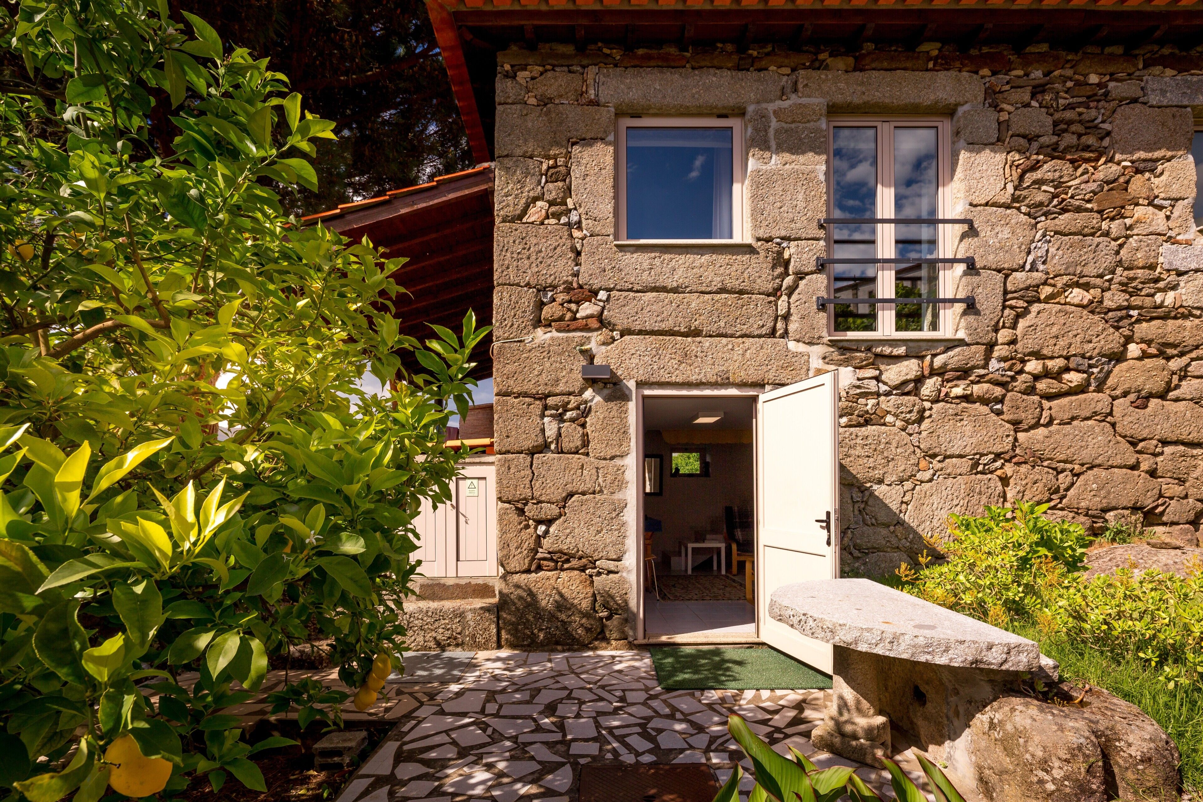 A stone building with a stone facade, a small window, and a door leading to an interior space.