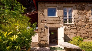 A stone building with a stone facade, a small window, and a door leading to an interior space. - Lemon Tree at Terrus Winery (Barrô, Viseu)