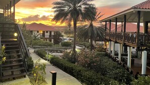 A resort with a covered walkway, palm trees, and a sunset view. - ⭐ Blue Bay BEACH villa, minutes walk to beach/pool/golf⭐ 🧡 3BR/2BA (Sint Michiel)