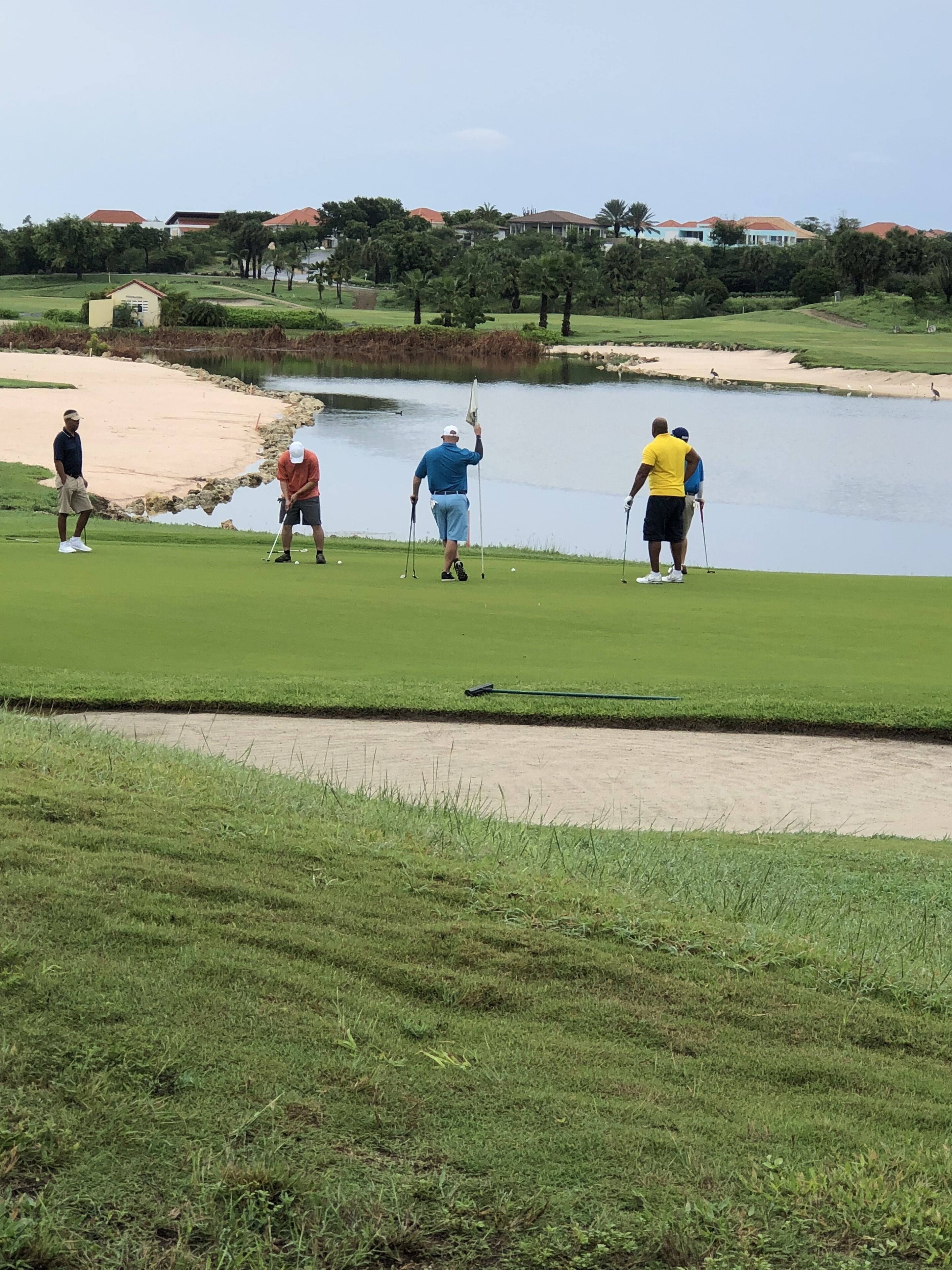 Un parcours de golf doté d’un étang, de bunkers de sable et d’un obstacle d’eau.