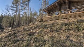 Eine Holzhütte mit Balkon und einer Treppe, die hinaufführt.