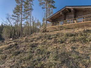 Een chalet met een houten gevel, een balkon en een trap er naartoe.