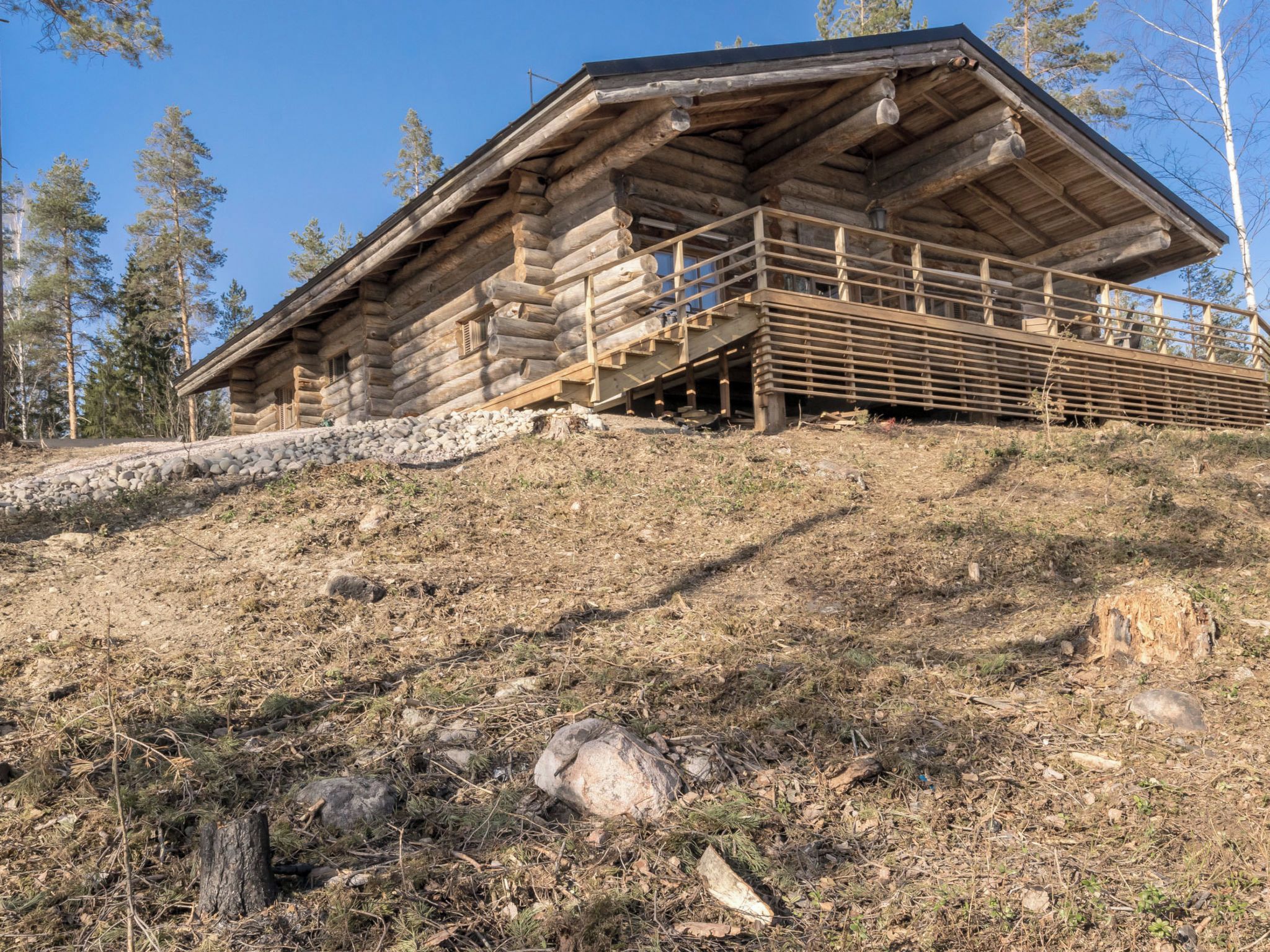 A log cabin with a wooden staircase leading up to a porch.