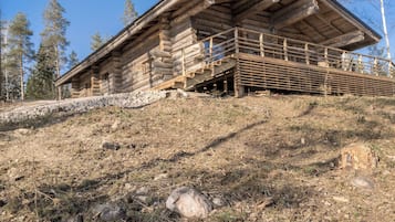 A log cabin with a wooden staircase leading up to a porch.