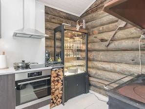 A modern kitchen with a built-in wine fridge, oven, and stove.