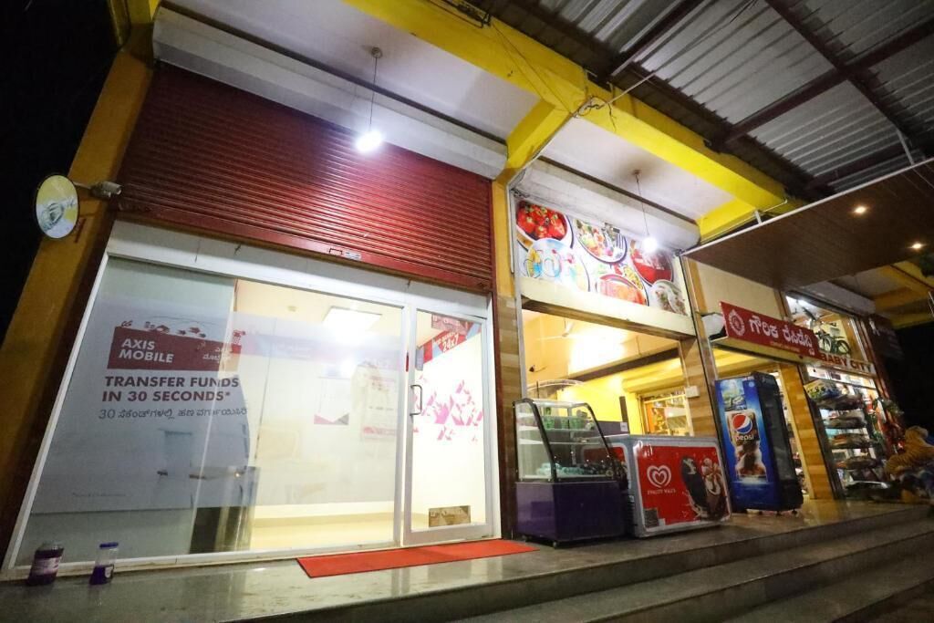 Un escaparate con una persiana baja, una máquina expendedora de Pepsi y un cartel que anuncia servicios de transferencia móvil.