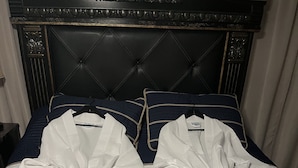 Ein Bett mit dunklem Kopfteil und gestreifter Bettwäsche.