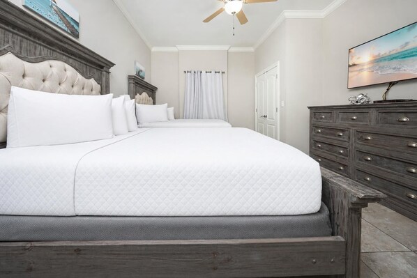 A bedroom with a large bed, a ceiling fan, a dresser, and a TV on the wall. - Relax, Float & Enjoy the Gulf 3 Bedroom 3 Bath Phoenix Orange Beach 905 (Orange Beach)