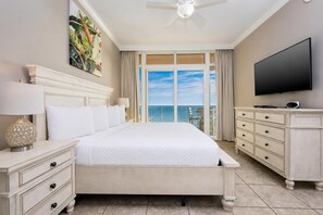 A hotel room with a large bed, a TV, a dresser, and a balcony with a view. - Panoramic Gulf Views 4 Bedroom 7th FLOOR! Phoenix Orange Beach 701 (Orange Beach)