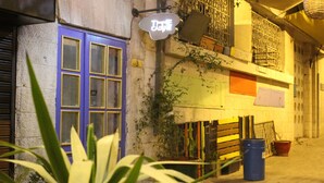 A narrow street with a blue door and a sign that reads "Cafe". - The Cabin Hostel (Amman)