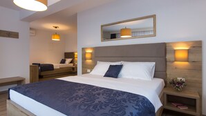 A modern hotel room with a large bed, a bedside table with a lamp, and a mirror on the wall. - B&B Villa Maris (Punat)