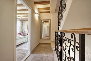Enter a serene space with a comfortable bed, large mirror, and natural light pouring in through the window.