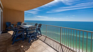 A balcony with a table and chairs, overlooking a clear blue sea. - Chill, Splash, Relax BEACH FRONT Phoenix Orange Beach 2005 (Orange Beach)