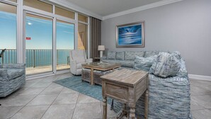 A living room with a view of the ocean, a sofa, a chair, a coffee table, and a lamp. - Chill, Splash, Relax BEACH FRONT Phoenix Orange Beach 2005 (Orange Beach)