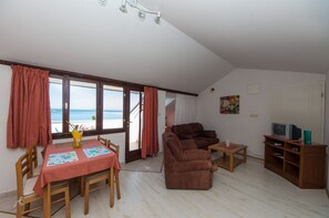 Familien-Studiosuite, Meerblick | Wohnbereich | 82-cm-Flachbildfernseher mit Premium-TV-Sendern, LCD-Fernseher