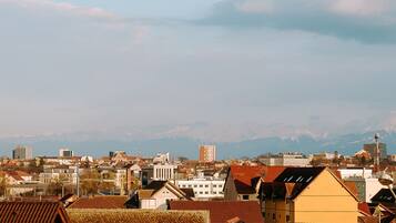 Bybillede med forskellige bygninger, herunder boliger og en kirke med et højt spir.