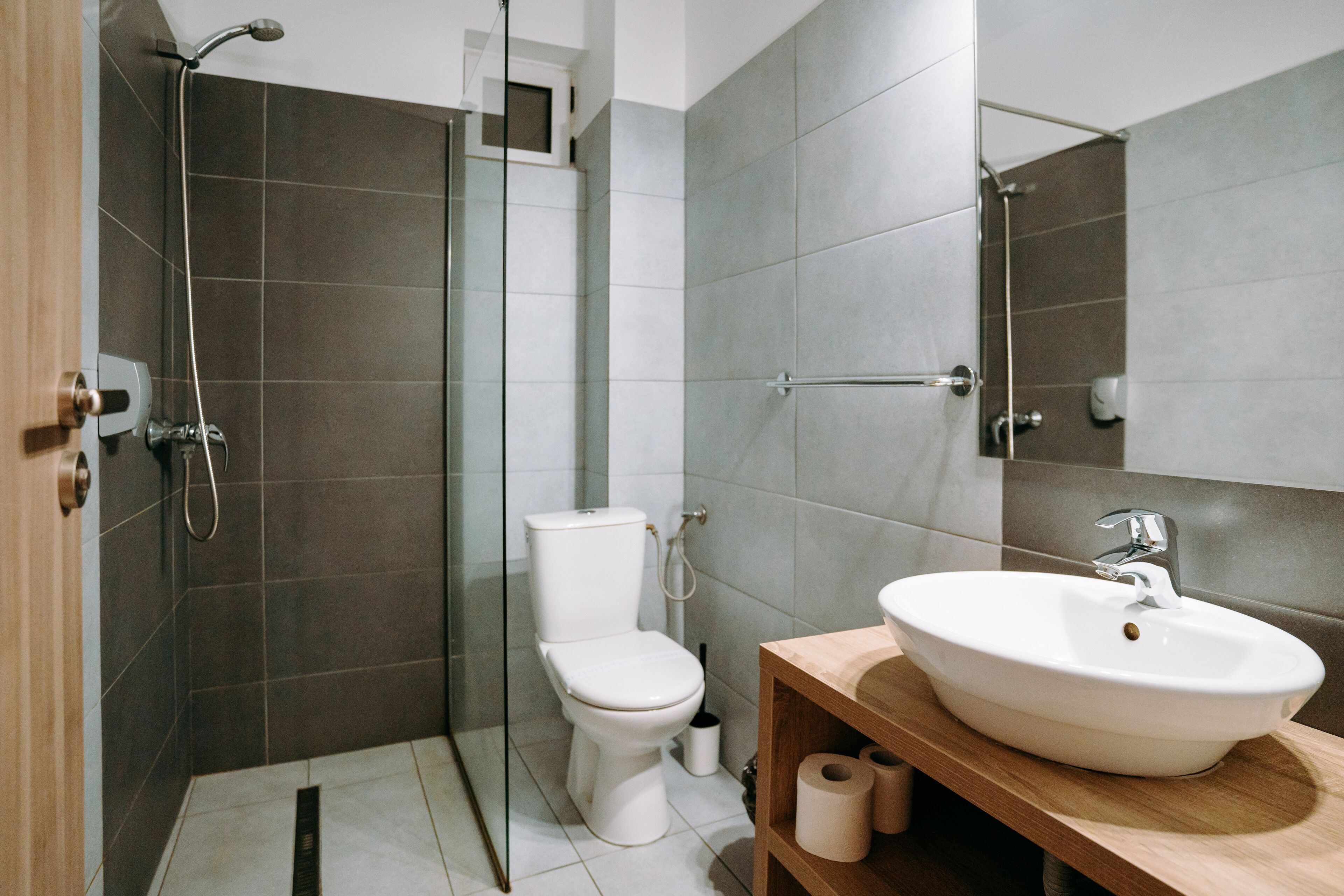 Un baño moderno con ducha, inodoro y lavamanos.
