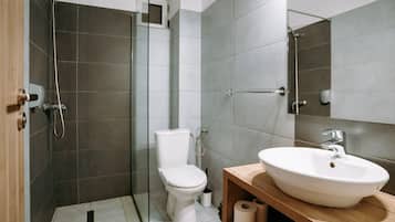 Un baño moderno con ducha, inodoro y lavamanos.
