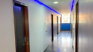 A long, narrow hallway with a blue LED light strip running along the ceiling.