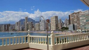 A balcony with a view of a beach and city skyline.