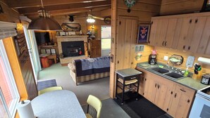 A cozy cabin interior with a dining area, kitchen, and living space.