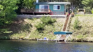 A dock extending into a body of water with a small house and a staircase leading up to it.
