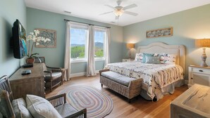 A bedroom with a bed, a ceiling fan, a window with curtains, a television, and a desk with a chair. - Chalakee Lodge CD-5- Mountain View, Gated Resort, Indoor/Outdoor Pools & Hot Tub (Boone)