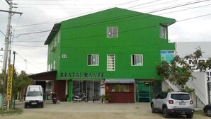 Um edifício verde com uma placa na entrada que diz "RESTAURANTE".