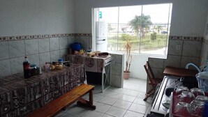 Cozinha compacta com área de refeições, janela com vista e geladeira.