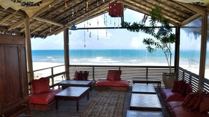 Une terrasse en bois avec des sièges et une vue sur l’océan.