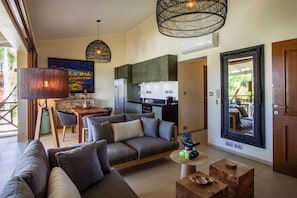 A modern living room with a sofa, coffee table, and dining area.