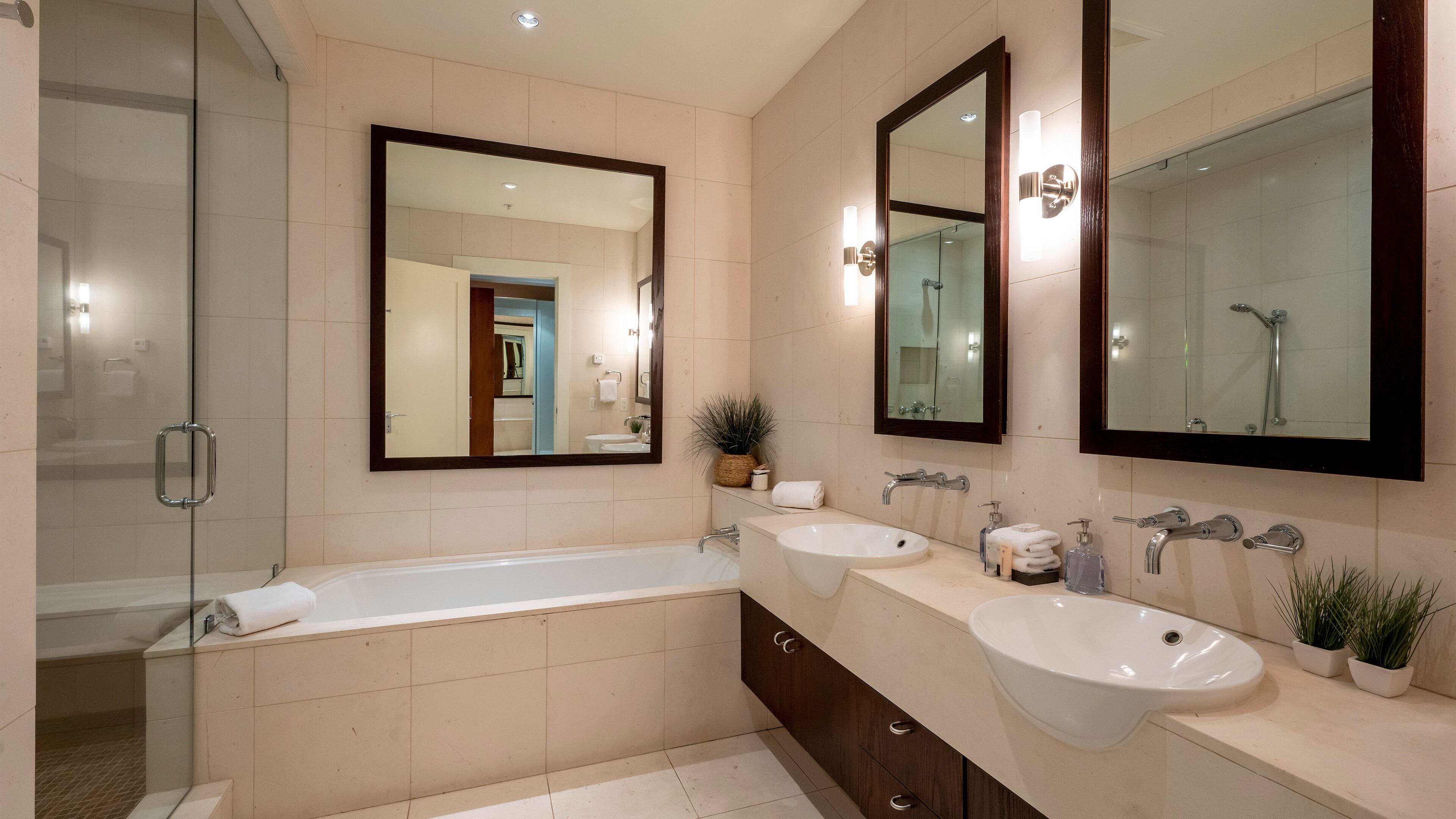 Une salle de bain moderne avec une grande baignoire, deux lavabos et des miroirs.