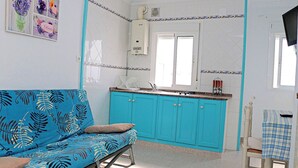 A small, bright kitchen with turquoise cabinets, a white countertop, and a window above the sink. - One bedroom apartment with WiFi (CONIL DE LA FRONTERA)