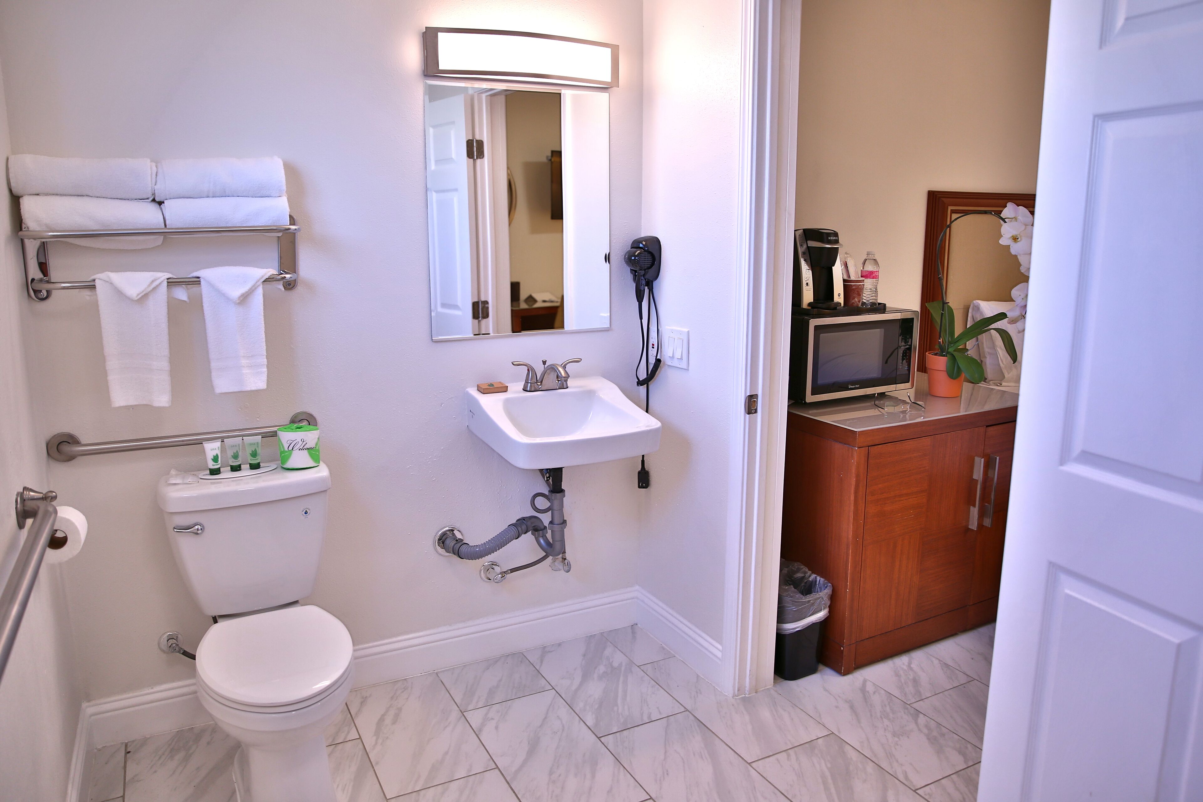 Ein Badezimmer mit Toilette, Waschbecken und einem kleinen Schrank mit Spiegel.