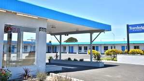 A motel with a blue awning, a '444' sign, and a 'Travelodge by Wyndham' sign. - Travelodge by Wyndham Crescent City (Crescent City)