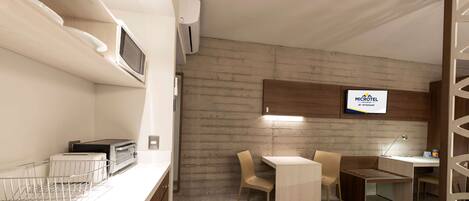 A modern kitchen with a microwave, toaster, and a small dining area with a table and chairs.