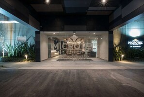 A modern hotel entrance with a glass facade, a reception desk, and a sign for 'MICROTEEL BY WYNDHAM'. - Microtel Inn & Suites by Wyndham Irapuato (Irapuato)