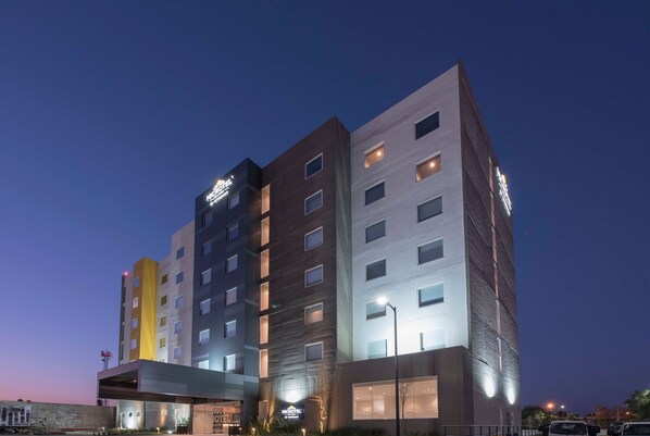 A multi-story hotel with a modern design, featuring a prominent entrance and multiple windows. - Microtel Inn & Suites by Wyndham Irapuato (Irapuato)