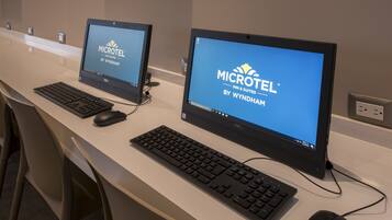 Duas estações de trabalho com computadores e monitores exibindo o logotipo do Microtel Inn & Suites by Wyndham.