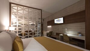 A hotel room with a bed, a desk, and a TV displaying 'MICROTEL BY WYNDHAM'. - Microtel Inn & Suites by Wyndham Irapuato (Irapuato)