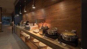 A modern kitchen with a long counter, wooden wall, and overhead lighting. - Microtel Inn & Suites by Wyndham Irapuato (Irapuato)