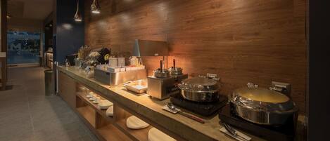 Una cocina moderna con una encimera alargada, pared de madera e iluminación empotrada.