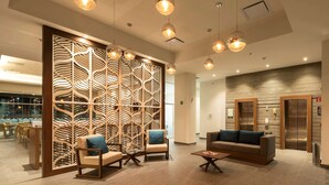 A modern lobby with a wooden partition, seating area, and a reception desk. - Microtel Inn & Suites by Wyndham Irapuato (Irapuato)