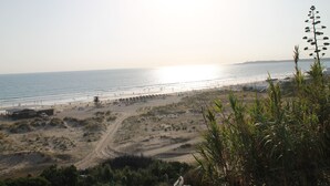 A beach with a clear path leading to the water, a lifeguard tower, and a row of beach umbrellas. - Very central apartment with WiFi (CONIL DE LA FRONTERA)