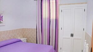 A bedroom with a bed, a wardrobe, and a bathroom with a shower curtain. - Central one bedroom apartment with WiFi (CONIL DE LA FRONTERA)