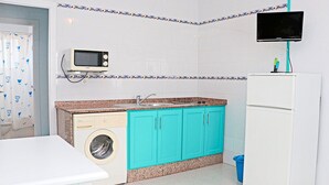 A compact kitchen with a washing machine, a microwave, a sink, and a refrigerator. - Great location close to the beach (CONIL DE LA FRONTERA)