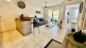 Cozinha moderna com bancada, área de refeições com sofá e vista para o exterior.
